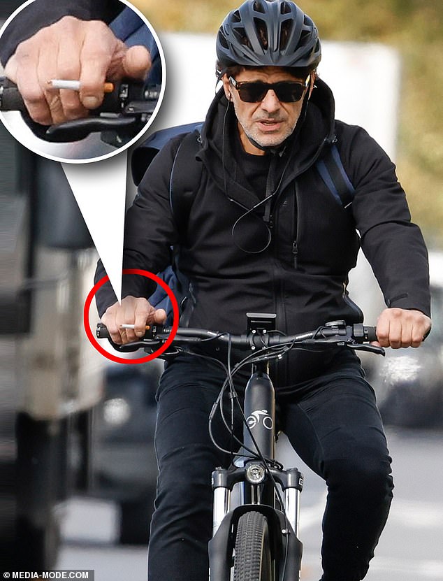 Fue fotografiado fumando un cigarrillo mientras recorría los carriles para bicicletas con una sudadera con capucha negra, jeans oscuros y lentes de sol.