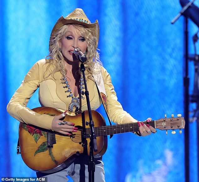 La cantante de country con sombrero de vaquera y mangas largas amarillas de piel sintética.