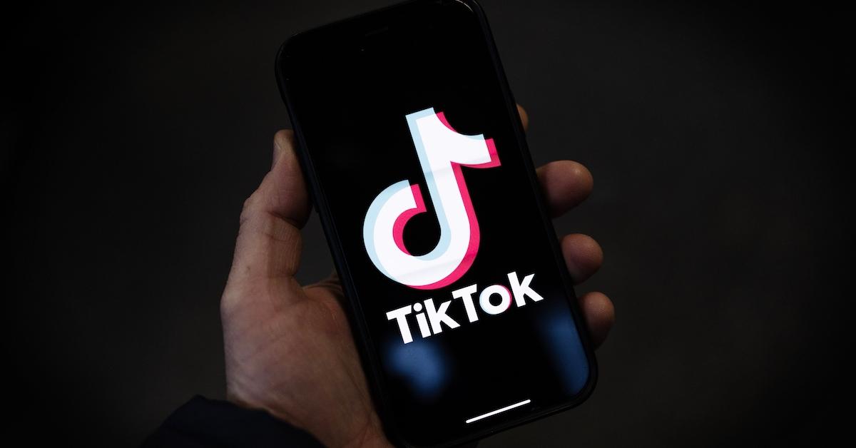 Una persona que sostiene un teléfono inteligente que muestra el logotipo de TikTok