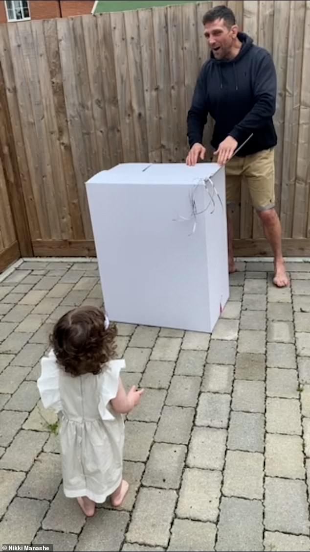 Preparándose: el video muestra al ex artista marcial mixto Alex, de 47 años, en el jardín con una gran caja de cartón blanca, con la pequeña Anastasia observando ansiosamente.