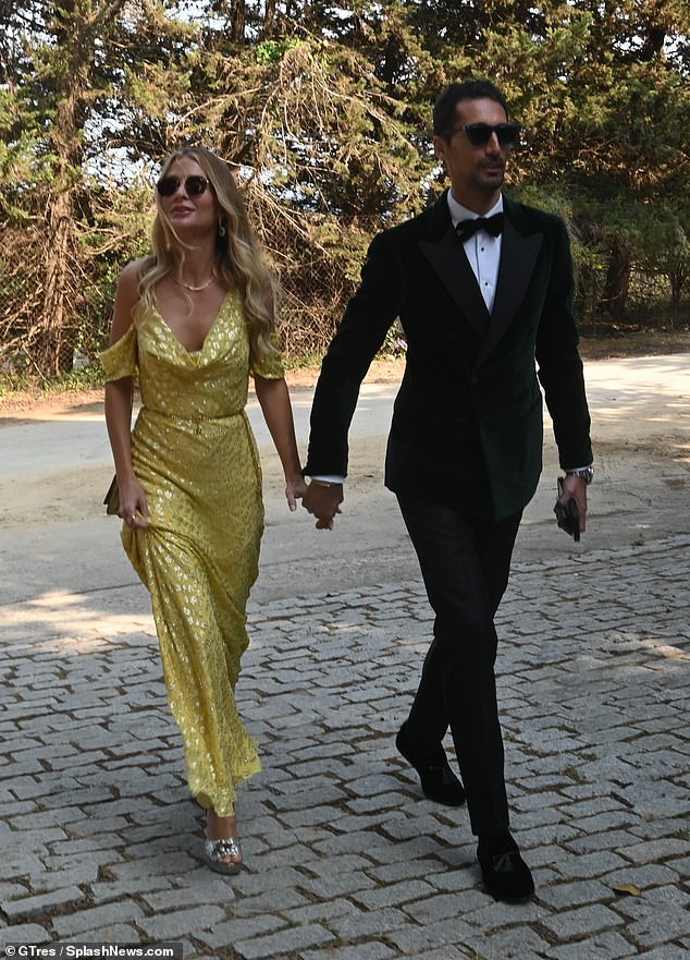 Sofisticada: Millie, de 33 años, optó por un vestido largo amarillo para la ocasión, con su esposo Hugo, de 36, luciendo elegante con un blazer verde de terciopelo.