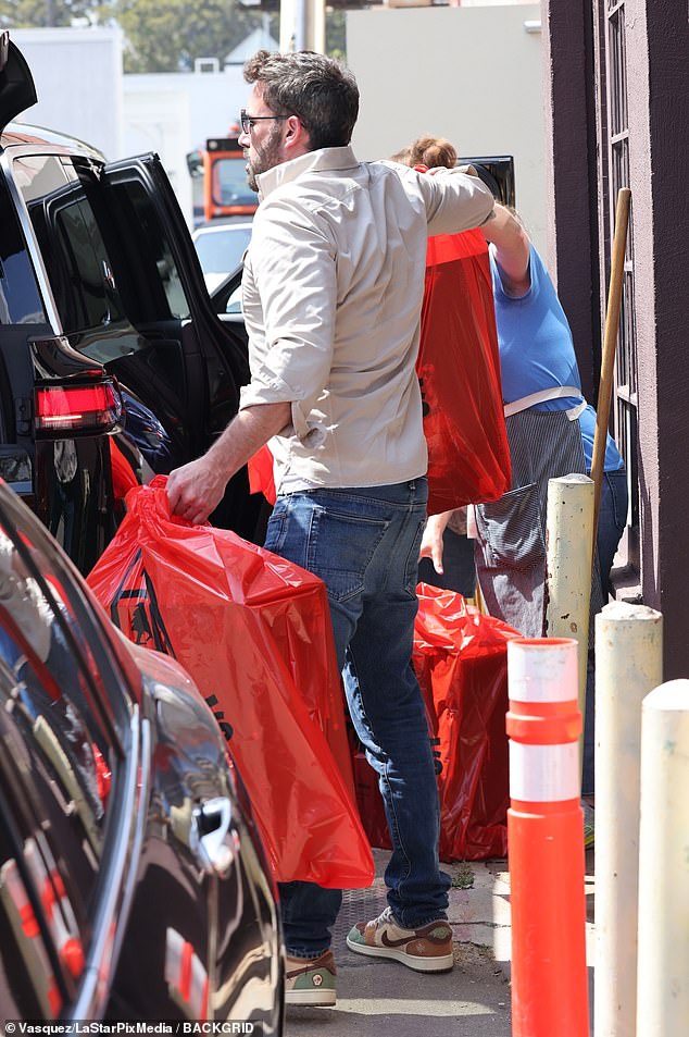 Cargando el automóvil: Affleck ayudó a cargar una gran cantidad de bolsas naranjas en su automóvil estacionado cerca de un edificio