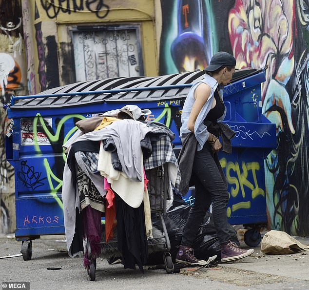 Loni Willison hurga en la basura en un callejón en busca de alimentos y suministros para la vida el 20 de mayo de 2023