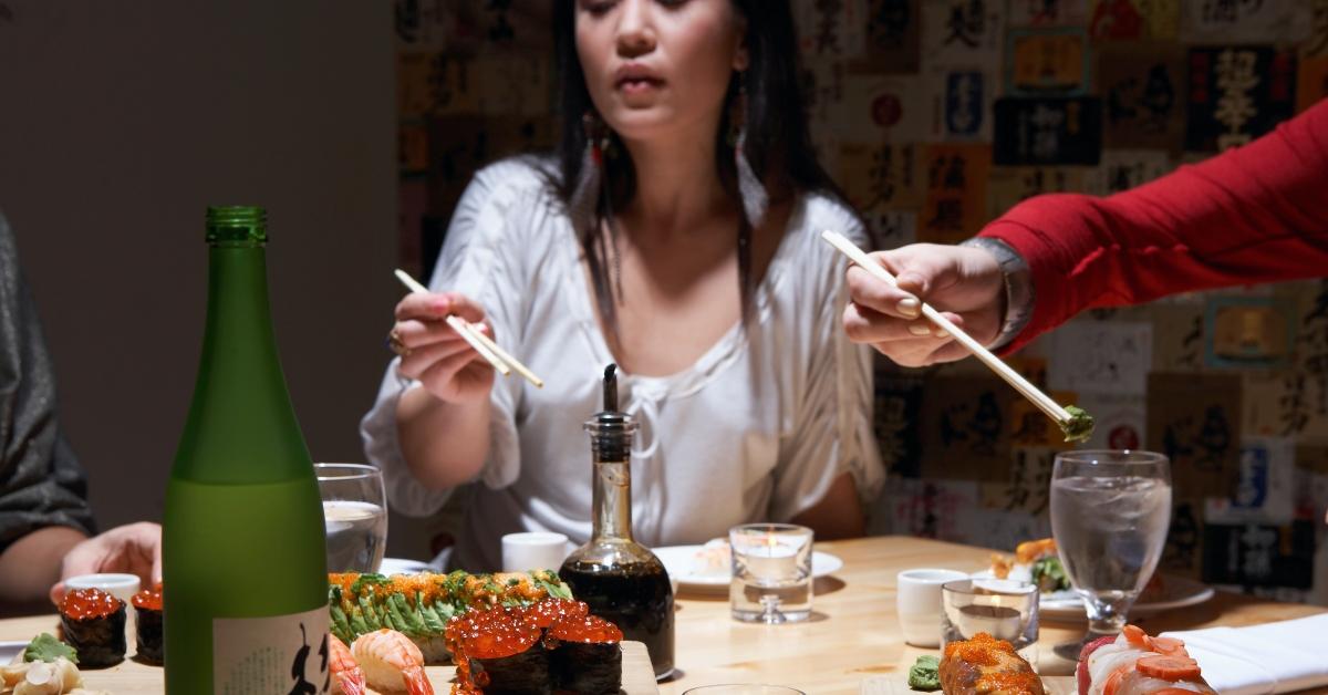 mujeres jóvenes comiendo sushi en el restaurante