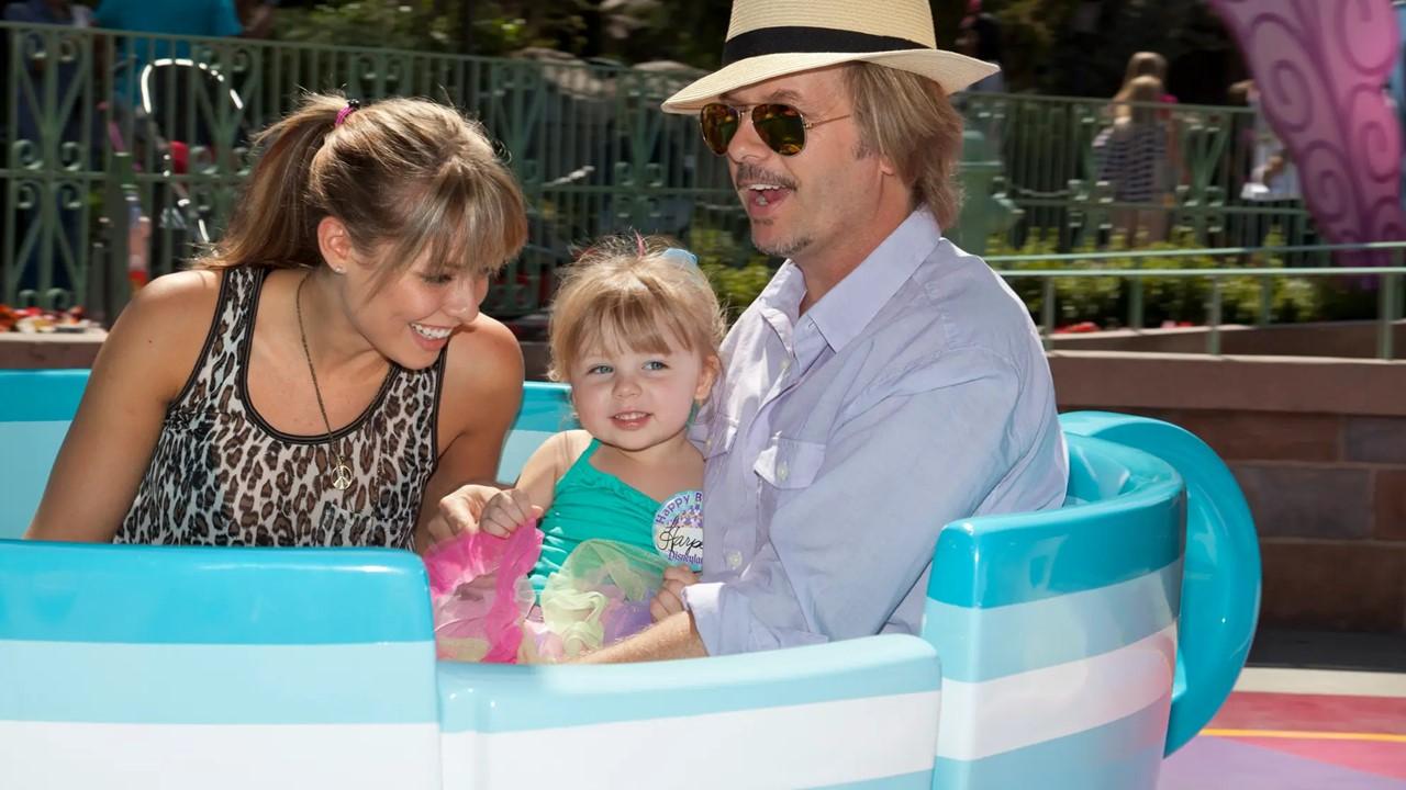 Jillian Grace and David Spade with their daughter Harper on a ride at Disneyland
