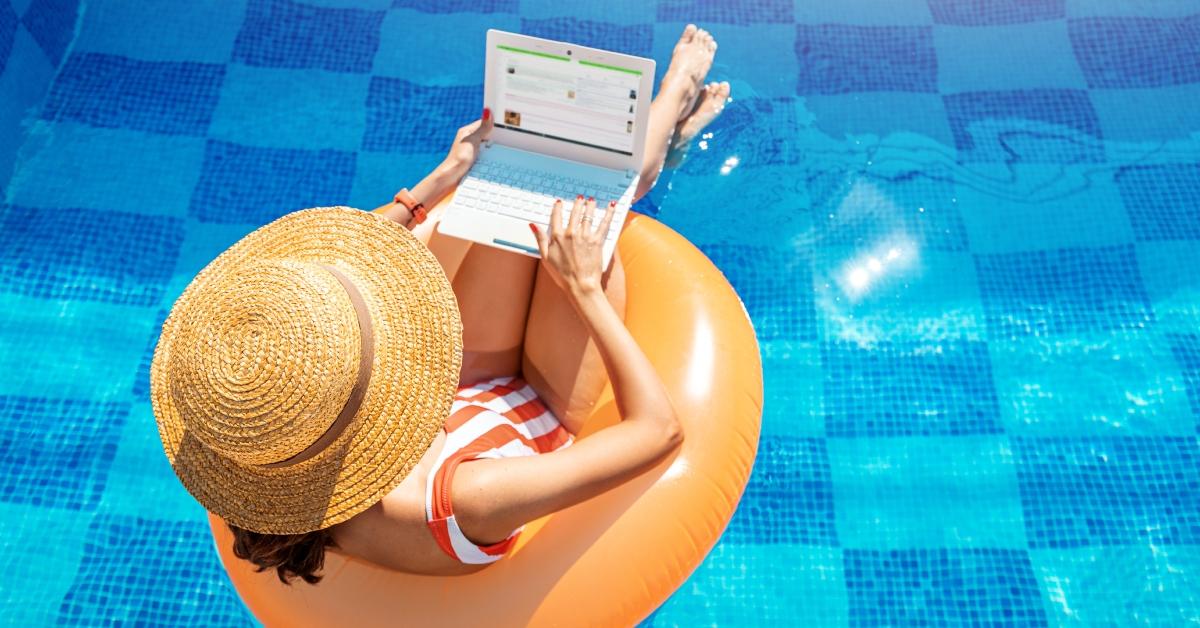 Woman using her laptop while in a swimming pool.