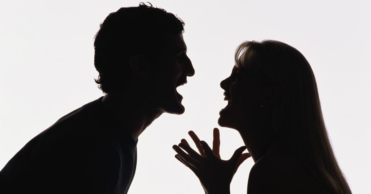 A silhouette of a couple yelling at each other.