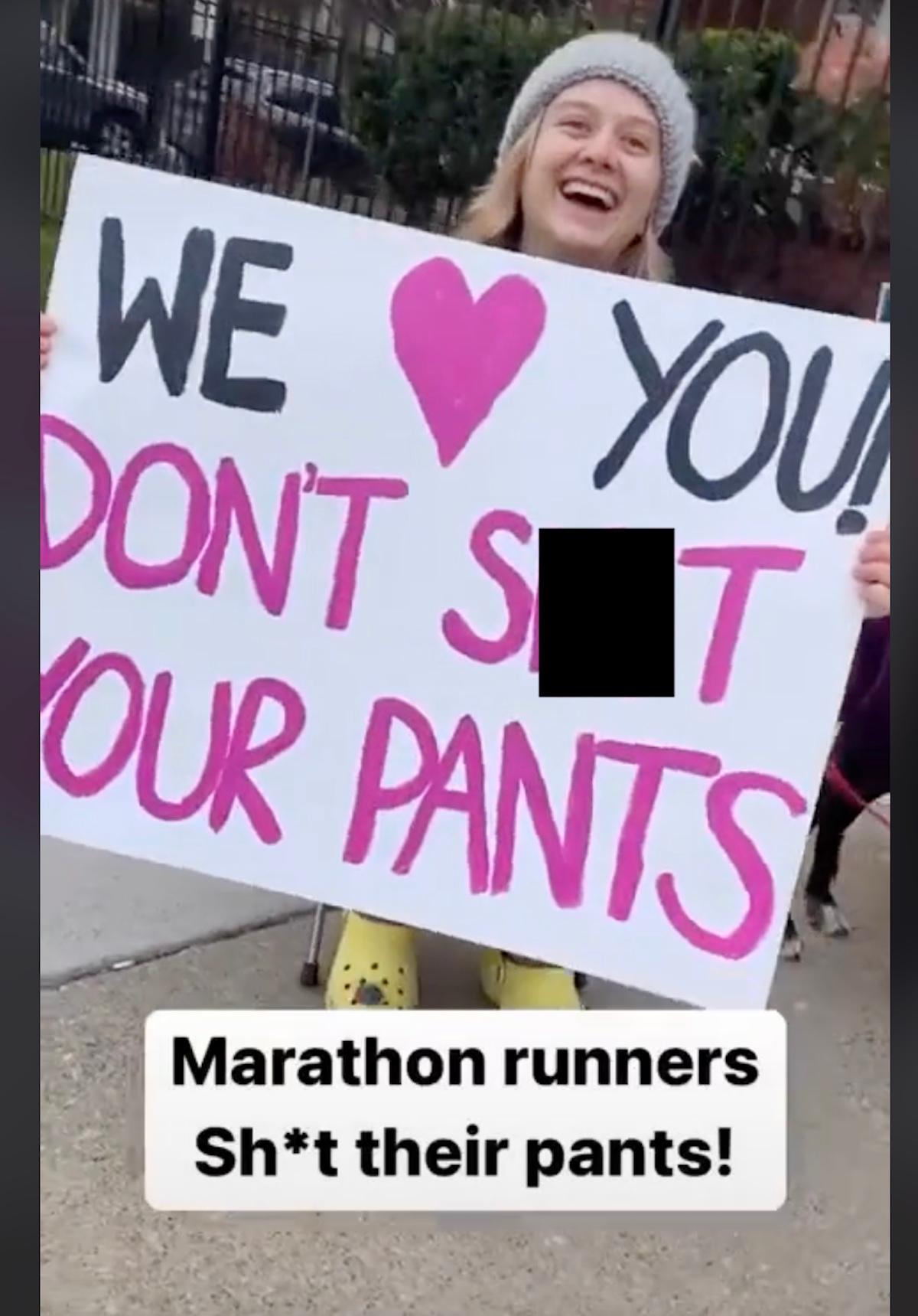 Una mujer sosteniendo un cartel que dice "Te queremos, no te cagues en los pantalones."